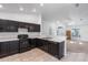 Kitchen with view into living room, showcasing black appliances and neutral color scheme at 205 Lori Ct, Umatilla, FL 32784