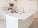 Kitchen island with stainless steel sink and appliances in white cabinetry at 2144 Hibiscus Pl, Kissimmee, FL 34759
