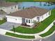 Aerial view of home with three-car garage, landscaping, and a pond nearby at 2152 Rock Maple Bnd, Kissimmee, FL 34746