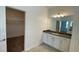 Bright bathroom featuring white cabinetry, a large mirror, and modern lighting fixtures at 2152 Rock Maple Bnd, Kissimmee, FL 34746