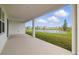 Covered patio with a view of the grassy lawn, serene lake, and neighboring houses at 2152 Rock Maple Bnd, Kissimmee, FL 34746