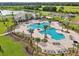 Aerial view of the pool with plenty of seating and beautiful palm trees in a landscaped setting at 2152 Rock Maple Bnd, Kissimmee, FL 34746
