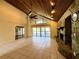 Bright living room with vaulted wood ceilings, tile floors, stone fireplace, and access to the pool at 2155 Palm View Dr, Apopka, FL 32712