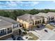Aerial view of a multi-story yellow home with a covered balcony, surrounded by trees and other homes at 2256 Betsy Ross Ln, St Cloud, FL 34769