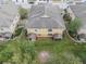 Aerial view showcasing the back of a yellow house and its green surroundings at 2256 Betsy Ross Ln, St Cloud, FL 34769