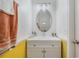 Bathroom with a white vanity, decorative lighting, oval mirror and yellow accent wall at 2256 Betsy Ross Ln, St Cloud, FL 34769