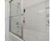 Clean and modern shower and tub combination in an all-white bathroom with glass door at 2256 Betsy Ross Ln, St Cloud, FL 34769