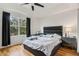 Bedroom with hardwood floors, a dark padded headboard, and large windows with light and views at 2256 Betsy Ross Ln, St Cloud, FL 34769
