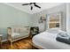 Cozy Bedroom featuring a crib, chair, wood flooring, and soft, natural light from the window at 2256 Betsy Ross Ln, St Cloud, FL 34769