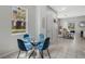 Sunlit dining area with a glass table, blue chairs, and tile flooring at 2256 Betsy Ross Ln, St Cloud, FL 34769