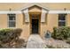 Attractive entrance with a black front door, manicured shrubs, and light colored facade at 2256 Betsy Ross Ln, St Cloud, FL 34769