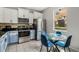 Bright kitchen featuring stainless steel appliances, white upper cabinets, and an adjacent table at 2256 Betsy Ross Ln, St Cloud, FL 34769