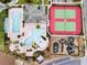An aerial view shows the community swimming pools, playground, and tennis courts with lush green surroundings and palm trees at 2311 Victoria Dr, Davenport, FL 33837