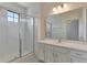 Well-lit bathroom featuring a tiled shower with glass doors and a white vanity at 2311 Victoria Dr, Davenport, FL 33837