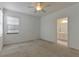 Bright bedroom with neutral carpet, ceiling fan, and window with bathroom access at 2311 Victoria Dr, Davenport, FL 33837