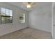 Bedroom with natural light from two windows, neutral carpet and paint, and a ceiling fan at 2311 Victoria Dr, Davenport, FL 33837