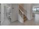 Bright entryway showcasing stairs, bathroom and open living area with tile floors and neutral paint at 2311 Victoria Dr, Davenport, FL 33837