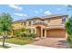 Inviting two-story home with a two-car garage and meticulously landscaped front yard at 2311 Victoria Dr, Davenport, FL 33837