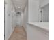 Bright hallway with neutral carpet and paint leading to multiple rooms, showcasing accessibility at 2311 Victoria Dr, Davenport, FL 33837