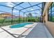 Backyard pool featuring a screened enclosure, lush landscaping, and patio space at 2311 Victoria Dr, Davenport, FL 33837