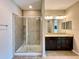 Bathroom with a tiled shower and a dual-sink vanity with granite countertops at 254 Alford Dr, Davenport, FL 33896