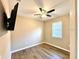 Cozy bedroom with wood-look flooring, a ceiling fan, and a window providing natural light at 254 Alford Dr, Davenport, FL 33896