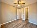 A cozy bedroom featuring wood-look flooring, neutral walls, and ceiling fan at 254 Alford Dr, Davenport, FL 33896