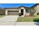 Charming single-story home features an attached two-car garage and manicured landscaping at 254 Alford Dr, Davenport, FL 33896