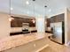 Modern kitchen boasting a granite island, dark cabinets, and stainless steel refrigerator at 254 Alford Dr, Davenport, FL 33896