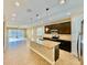 Open-concept kitchen featuring a large granite island, dark cabinetry, and stainless steel appliances at 254 Alford Dr, Davenport, FL 33896