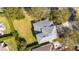 Aerial view of a home's gray roof surrounded by lush greenery and a large grassy lawn at 2602 Shirehall Ln, Winter Garden, FL 34787