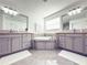 A full bathroom with double sinks, gray cabinets, a white tub and gray flooring at 2602 Shirehall Ln, Winter Garden, FL 34787