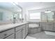 Spacious bathroom with tub, double vanity sinks with light countertops, gray cabinets, and tile floor at 2602 Shirehall Ln, Winter Garden, FL 34787