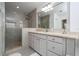 Beautiful bathroom featuring a shower with tile surround and double vanity sinks with neutral countertops at 2602 Shirehall Ln, Winter Garden, FL 34787
