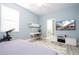Bedroom with desk, TV, stationary bike and calming blue walls in the home at 2602 Shirehall Ln, Winter Garden, FL 34787