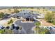 Aerial view of a clubhouse with a circular driveway and palm trees, with visible parking and golf course in the background at 2602 Shirehall Ln, Winter Garden, FL 34787