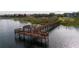 Picturesque view of a wooden gazebo-covered pier extending into a serene lake surrounded by lush vegetation at 2602 Shirehall Ln, Winter Garden, FL 34787