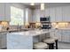 This bright eat-in kitchen features white cabinets, stainless appliances, a marble island with seating, and modern backsplash at 2602 Shirehall Ln, Winter Garden, FL 34787