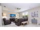 Bright living room with plush leather seating, ceiling fan, and a modern entertainment center at 2602 Shirehall Ln, Winter Garden, FL 34787