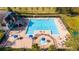 Aerial view of a community pool, featuring a large swimming area, lounge chairs, and a nearby building with stairs at 2602 Shirehall Ln, Winter Garden, FL 34787