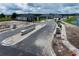 New home construction neighborhood entryway with stone pillar features and landscaping alongside a street and pond at 2672 Great Heron Ave, St Cloud, FL 34773