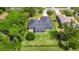Aerial view showing the backyard patio, driveway, and surrounding greenery at 275 W 3Rd St, Chuluota, FL 32766