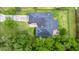 Aerial view showing the backyard patio, driveway, and surrounding greenery at 275 W 3Rd St, Chuluota, FL 32766