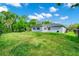 Spacious backyard features a lush lawn and views of the home's exterior at 275 W 3Rd St, Chuluota, FL 32766