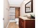 Cozy bathroom with a brown vanity, toilet, shower with tub and shower curtain, a mirror, and tan tile flooring at 275 W 3Rd St, Chuluota, FL 32766