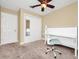 View of a bedroom featuring a ceiling fan, a closet with mirrored door, a desk with a chair, and neutral carpet at 275 W 3Rd St, Chuluota, FL 32766