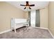 Neutral bedroom featuring a ceiling fan, desk with a chair, a window with light-filtering curtains, and cozy carpet at 275 W 3Rd St, Chuluota, FL 32766
