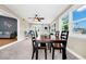 Bright dining room showcasing a black wood dining set, ceiling fan, and multiple windows overlooking the yard at 275 W 3Rd St, Chuluota, FL 32766