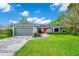 Charming home with stone accents, grey garage door, vibrant red door, and a lush green lawn at 275 W 3Rd St, Chuluota, FL 32766