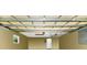 Spacious garage with overhead storage racks, utility door, window, and neutral painted walls at 275 W 3Rd St, Chuluota, FL 32766